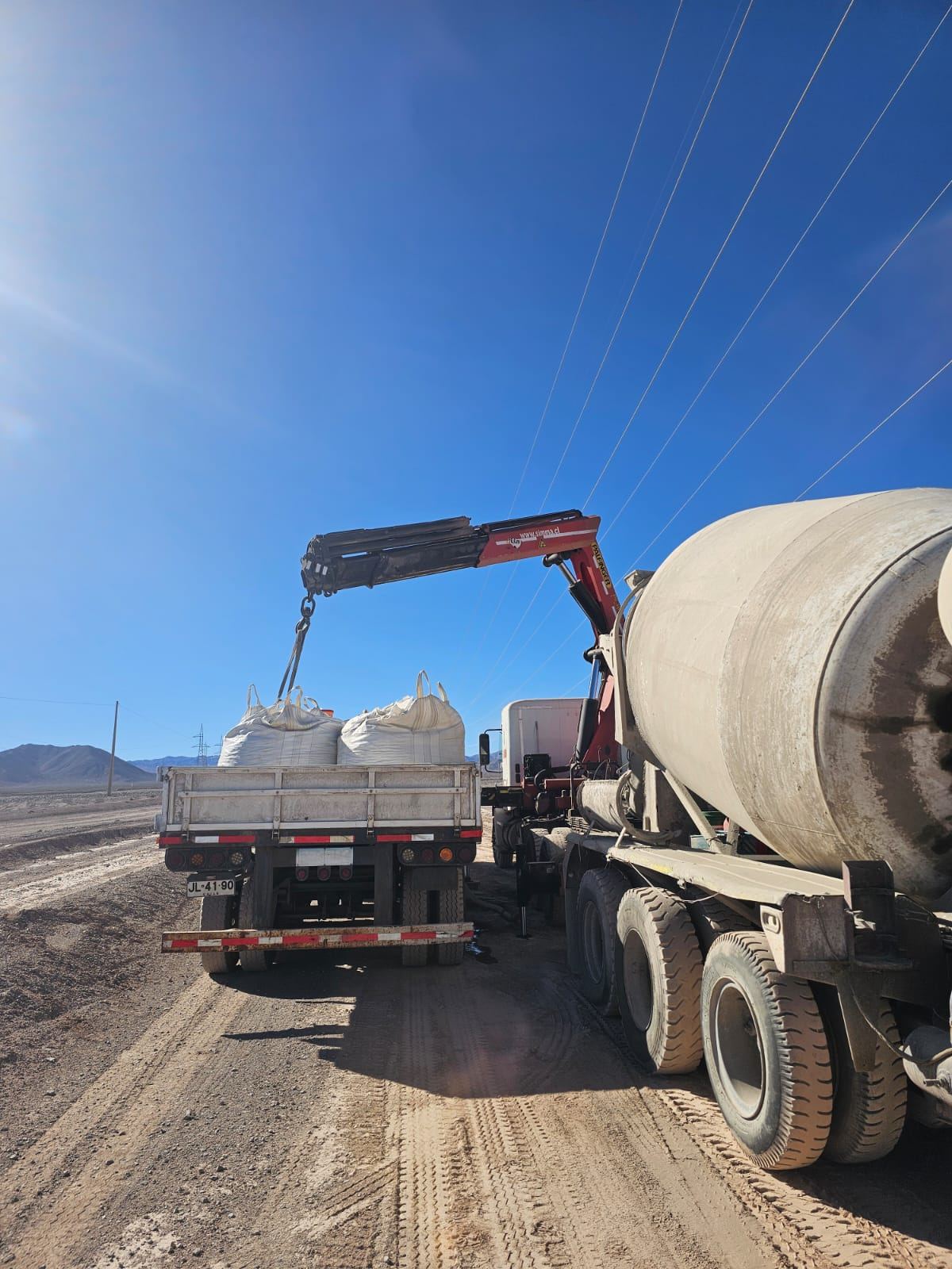 Camión mixer Menbar cargando áridos en ruta del desierto